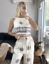 Conjunto de top sin mangas y pantalón palazzo con cintura elastizada, ambos de color crudo con estampado de flores y motivos geométricos en negro.
