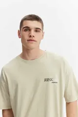 Remera boxy de algodón color verde claro con efecto lavado, de corte amplio y mangas cortas. Presenta un pequeño estampado en el pecho con la inscripción "RISK mistral".