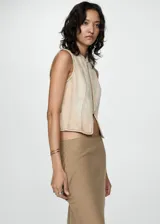 Top corto color beige con cierre frontal con cremallera, cuello redondo, sin mangas y costuras decorativas. Diseño entallado de algodón estilo tejano vaquero.