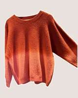 Sweater de punto con textura, diseño de cuello redondo y mangas largas, con un efecto degradado que va desde un tono bordó intenso en la parte superior hacia un tono más claro en la parte inferior.
