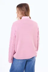 Buzo tejido de punto con diseño de trenzas, color negro, de corte holgado, cuello redondo y mangas largas.