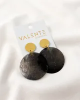 Aros colgantes con base circular dorada y dije circular grande de nácar con textura.