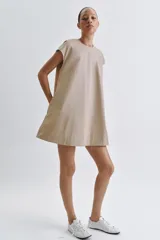 Vestido corto Zara de la colección ZW Collection, color beige, confeccionado en mezcla de algodón. Presenta cuello redondo, manga corta, bolsillos laterales ocultos en costura, bajo evasé y cierre en la espalda con cremallera.