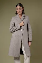 Tapado de corte sastre con diseño de espiga en tonos blanco y negro. Cuenta con solapas clásicas, cierre frontal de un botón y bolsillos laterales.