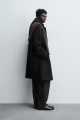 Abrigo regular fit de color negro, confeccionado con mezcla de lana y cashmere. Presenta cuello con solapas de muesca, manga larga, bolsillos de vivo en la cadera, abertura central en la espalda y cierre frontal de botonadura con tres botones.