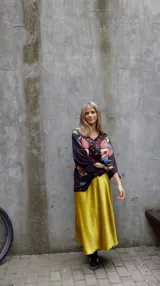 Falda midi evasé de raso color negro, con cintura elástica y cinturón con apliques metálicos.