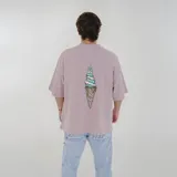 Remera color crema de corte holgado con cuello redondo y mangas cortas. Estampado pequeño en el pecho con texto en azul y amarillo.