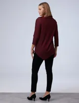 Blusa de tejido piqué con estampado geométrico en tonos negro y bordó. Presenta cuello volcado, mangas tres cuartos y un diseño de ruedo asimétrico.