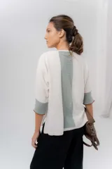 Buzo de punto confeccionado en lambswool, con diseño amplio, escote en V y mangas 3/4. Presenta una combinación de tonos rojos en la espalda con una franja central ancha y tajos laterales.