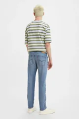 Jean de corte skinny con tiro medio, confeccionado en denim azul con efecto de lavado desgastado.