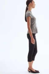 Top de punto fino color gris oscuro, con cuello redondo acanalado, mangas cortas tipo raglán y silueta acampanada (peplum).