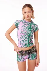Remera anatómica de manga corta confeccionada en tejido de poliéster con elastano y estampado de tigre en tonos rosa y verde.
