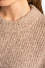 Chaleco de punto color beige con cuello alto y sisas amplias.