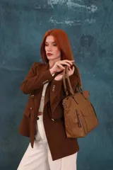 Cartera tipo tote de diseño estructurado en símil cuero, con doble asa rígida y correa regulable. Presenta múltiples bolsillos frontales con cierre y solapa, ofreciendo un estilo versátil y espacioso.