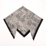Pañuelo rectangular de fondo blanco con estampado paisley en tonos negros y bordes negros.