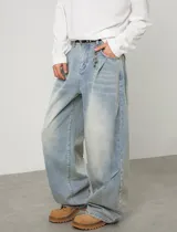 Jean baggy de tiro alto y lavado claro, con diseño amplio, pinzas y efecto desgastado en los muslos.