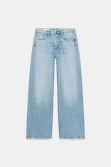 Jeans de tiro medio con diseño de cinco bolsillos y pierna ancha. Presenta un corte recto y holgado con bajo acabado sin costuras y cierre frontal con cremallera y botón metálico.