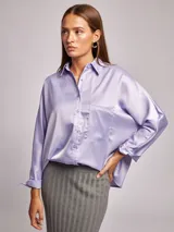 Camisa lila de satén, corte amplio, cuello solapa, manga larga y bolsillo de parche en el pecho.