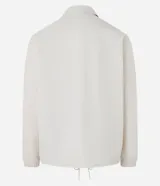 Campera color crema de poliéster con cuello inglés, abotonadura delantera con botón a presión, mangas largas con puño elástico, bajo elástico y cordón para ajustar.