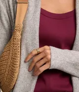 Cardigan alargado de punto color gris, con abertura frontal y bolsillos laterales.