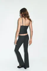 Pantalón de tiro bajo con corte flare y diseño de raya diplomática. Cuenta con cintura elástica para mayor comodidad y bajo acabado en línea evasé.