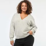 Sweater de punto gris melange con diseño cruzado tipo sobre, escote en V y mangas largas. Presenta detalles de strass dispersos por toda la prenda y terminaciones en tejido acanalado.