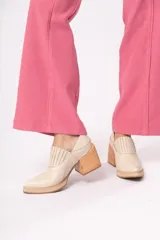 Zapato de cuero color beige con punta fina y taco de madera.