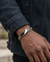 Pulsera de eslabones de acero con placa central rígida bicolor en negro y plateado, decorada con una pequeña circonia incrustada.