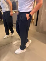 Pantalón sastrero de corte recto en color azul marino, con pinzas delanteras y trabillas para cinto.