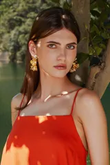 Aros colgantes dorados con diseño de pétalos superpuestos en forma de flor.