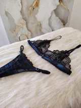 Conjunto de lencería compuesto por un bralette de encaje negro con breteles regulables y una tanga regulable con corte cola less y entrepierna de algodón.