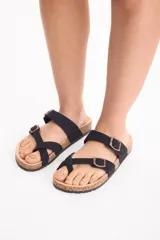 Sandalias negras de estilo Birkenstock con base de corcho, tiras cruzadas y ajuste de hebilla metálica.