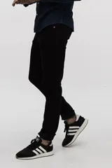 Jean skinny negro de tiro medio, con cierre de botón y cremallera, y bolsillos delanteros y traseros.