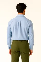 Camisa de lino color blanco, de corte clásico, con cuello camisero, cierre frontal de botones y bolsillo en el pecho.