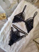 Conjunto de lencería compuesto por un bralette de encaje con detalle de aro central y una tanga colaless de doble tira regulable.