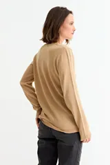 Sweater de punto fino en color gris con acabado metalizado, de corte recto, cuello redondo y manga larga.