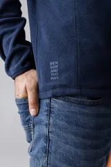 Campera de micropolar azul marino con cierre frontal parcial y bolsillo en el pecho.