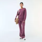 Pantalón de felpa ligera color púrpura, con corte bootcut y costura central vertical en el frente.