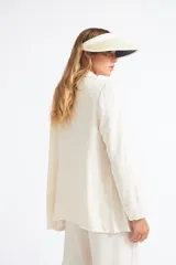 Visera de estilo clásico en color beige, con ala ancha y borde contrastante en color negro. Cuenta con una banda elástica posterior para un ajuste cómodo.