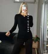 Remera de punto acanalado con escote redondo y cierre frontal parcial con botones. Presenta mangas largas y un ajuste entallado al cuerpo.