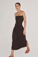 Vestido midi de corte bandeau con escote palabra de honor y detalle de vuelta en el pecho. Presenta una cintura entallada con pliegues y una falda con volumen en tejido combinado a tono.
