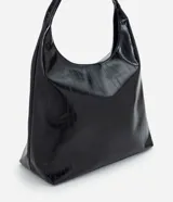 Cartera estilo hobo de gran tamaño, color negro, con superficie texturizada de líneas verticales. Presenta un diseño de media luna con asa ancha fija y abertura superior amplia.