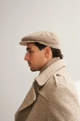 Boina con visera de lana fina uruguaya natural, sin teñir, con diseño de tejido texturizado en tonos beige y marrón.