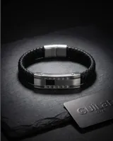 Pulsera de diseño masculino compuesta por una banda de cuerina trenzada negra y una pieza central de acero inoxidable con acabado pulido.