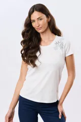 Remera blanca de manga corta y cuello redondo, confeccionada en algodón, con delicado bordado floral localizado en el hombro.