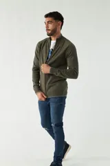 Campera tejida color verde militar, con cuello alto, puños y logo bordado.