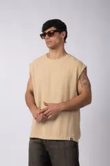 Musculosa oversize de tejido texturado color crema, con cuello redondo y terminaciones deshilachadas en las sisas. Presenta una costura central vertical en la espalda.