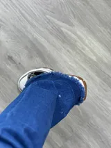 Pantalón de jean azul de corte wide leg, con cintura alta y terminación desflecada en el ruedo.