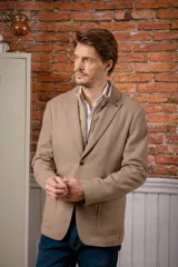 Saco sport color beige con pechera desmontable integrada, cierre frontal y solapas clásicas.