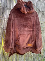 Canguro marrón de tela tipo peluche con capucha y bolsillo delantero.